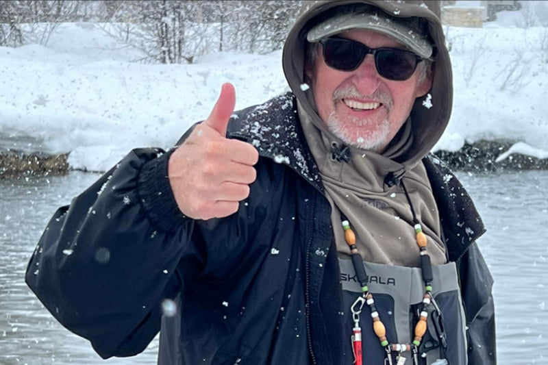 Bryan, Cofounder of Ducky Bobber,  fishing in the winter, giving a thumbs up. 