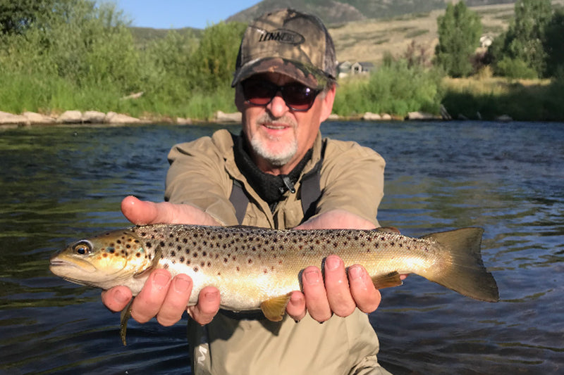 Bryan holding up a fish he caught. 