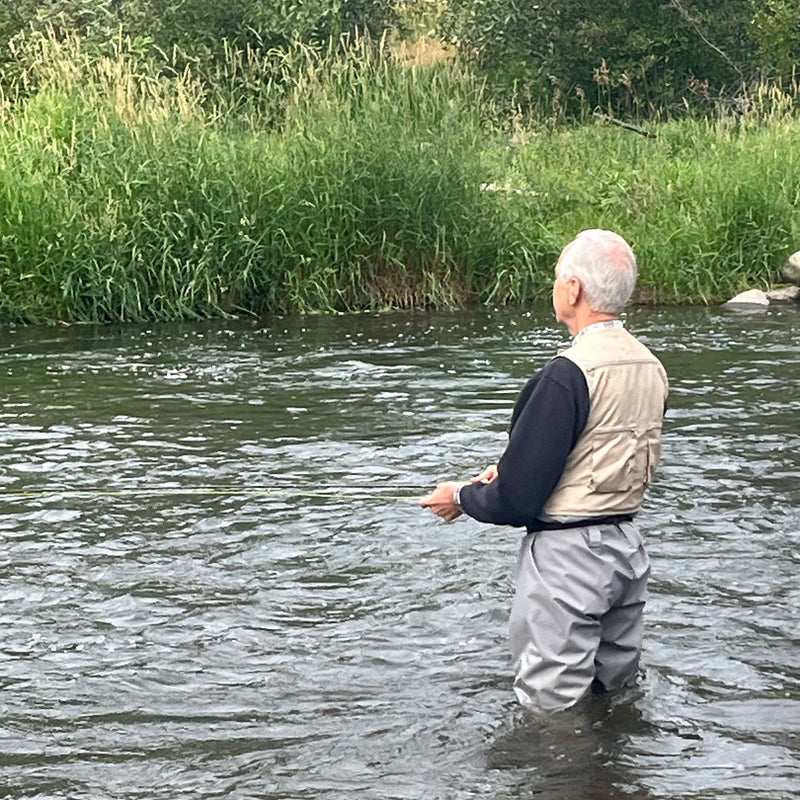 Stewart, Cofounder of Ducky Bobber,   with his back to the camera fishing.